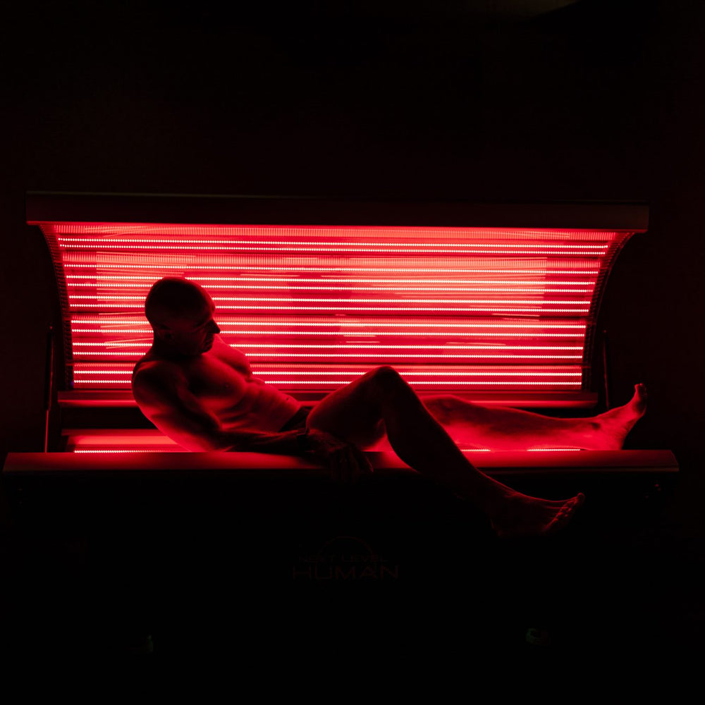 Man leunt ontspannen in het rood licht bed