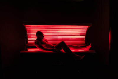 Man leunt ontspannen in het rood licht bed